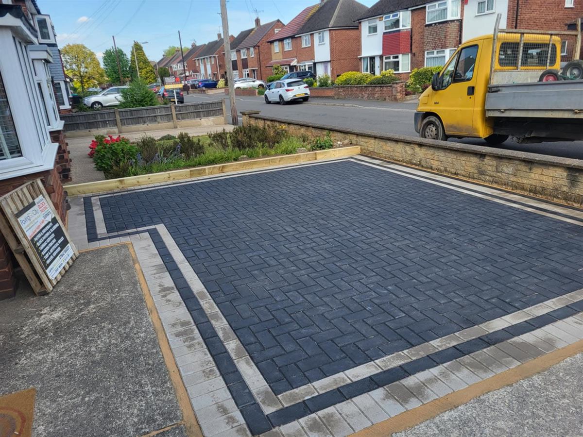 Charcoal block paved driveway finished up to a new kerb line