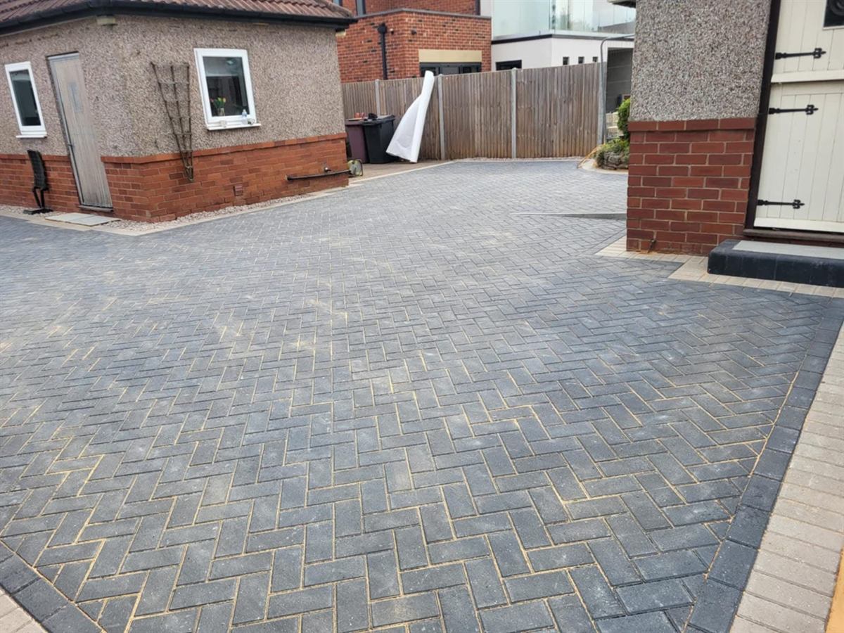 Block paved driveway running down the side of a house