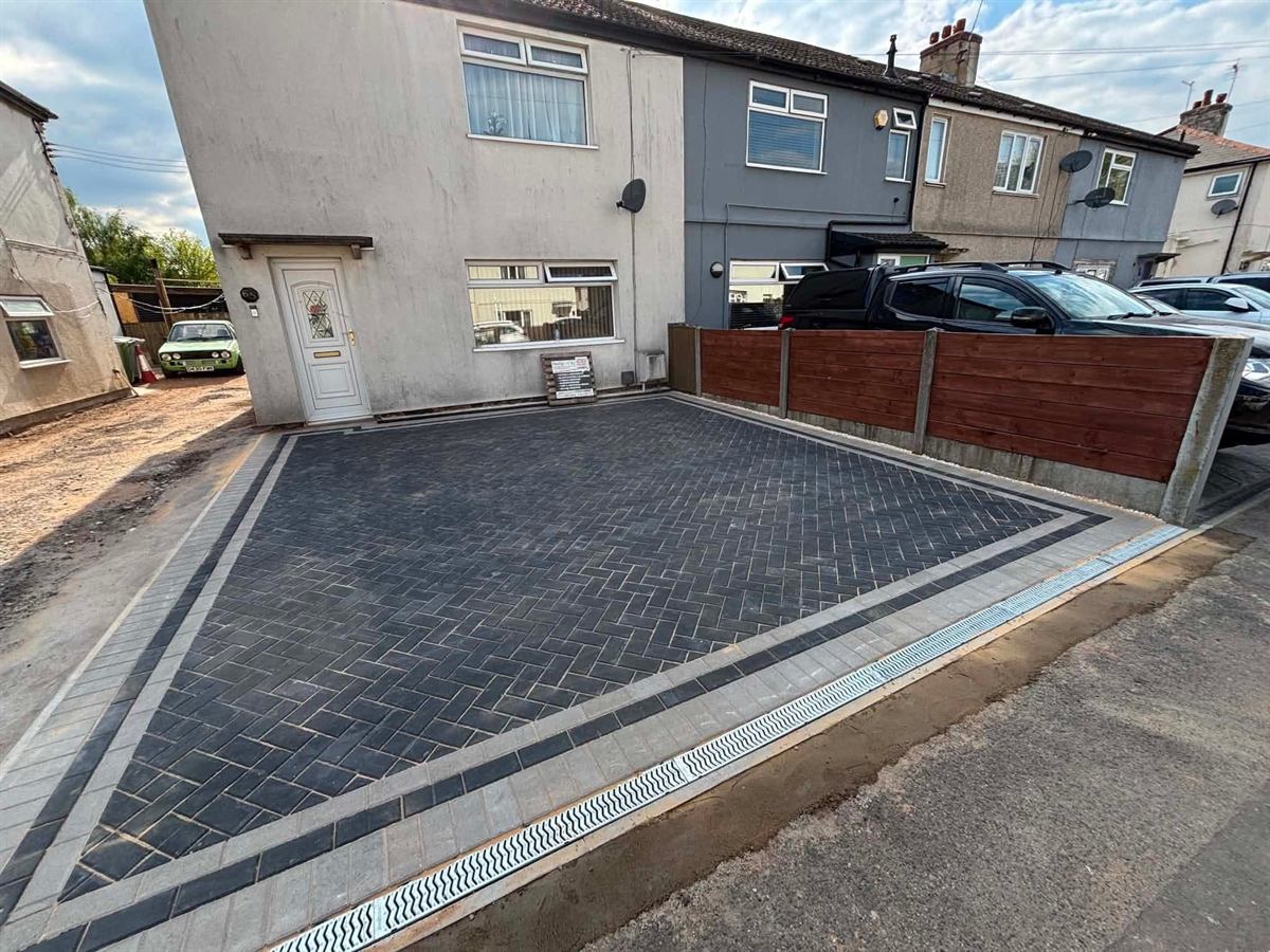 Block paved driveway with a channel drain across the entrance